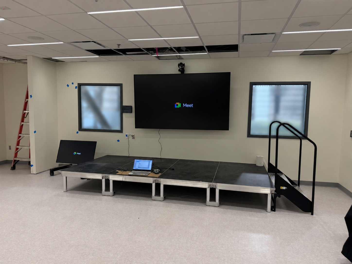 Large display and conferencing equipment being installed in a commercial room