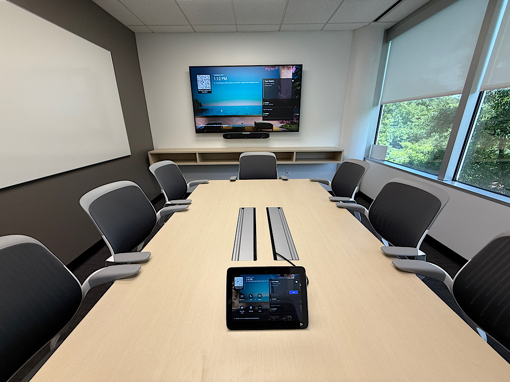 Conference room with wall display, video bar, and tabletop control panel